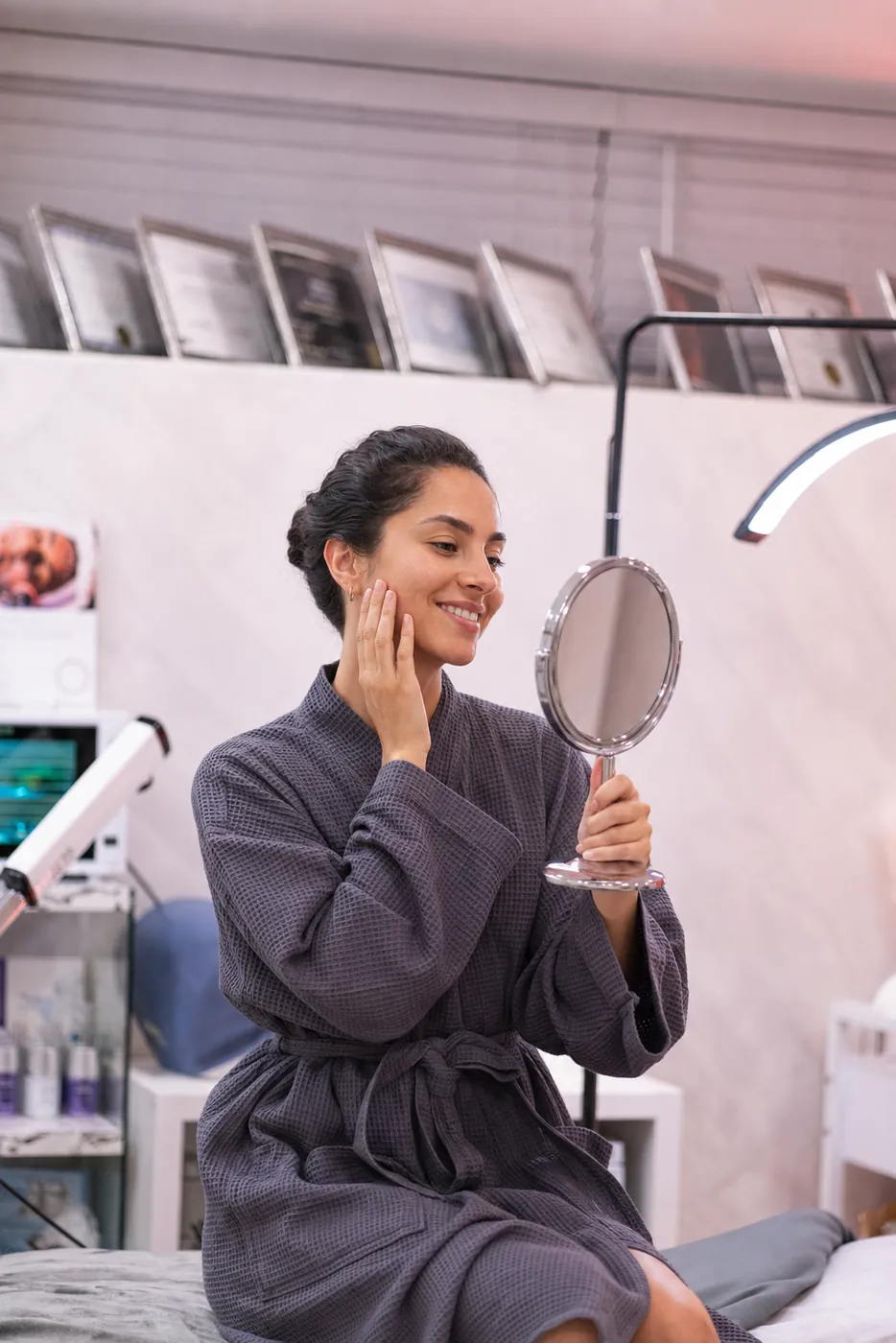 Client seeing her skin in the mirror after a facial at the Staten Island studio